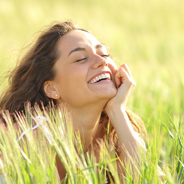 happy woman smiling enjoying the grass
